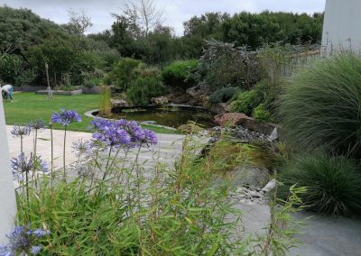 Allée pavée, jardin aménagé et bassin